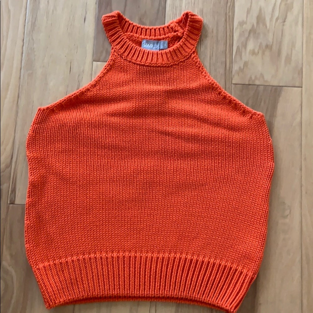 Orange sleeveless sweater top.